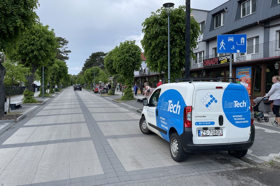 Samochód serwisowy LanTech zaparkowany przy nadmorskim deptaku.